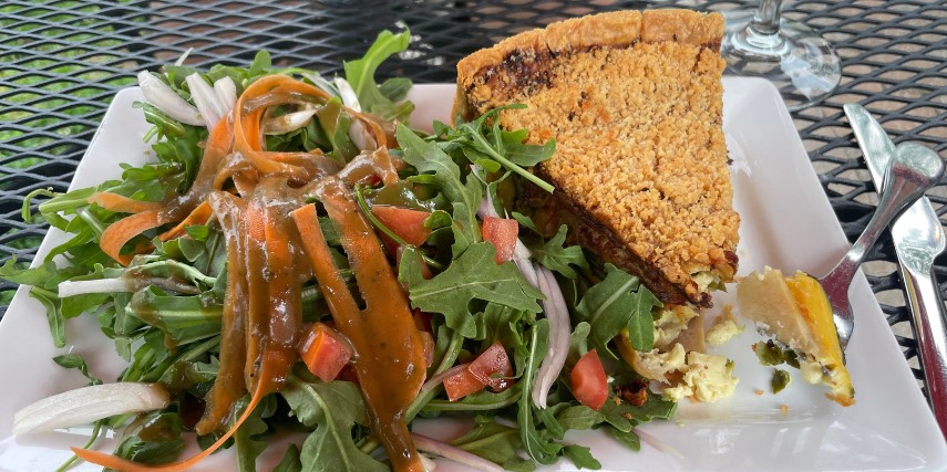 A parmesan-crusted chicken and spinach quiche with greens on the side: brunch at Russell's.