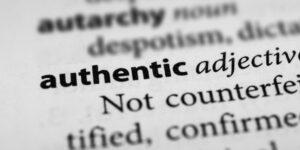 Close-up of a dictionary page, focused on the word "authentic."