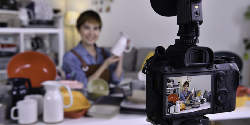 Shot of a video camera screen with the woman being recorded fuzzy in the background.