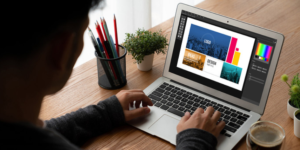 Person sits at a desk considering options for website design on a monitor.