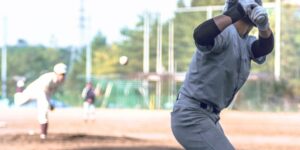 View of a batter from behind the plate, watching the pitcher wind up.