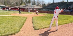 View of a batter in a white uniform getting ready to hit.