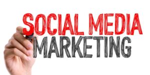 A hand writes "Social Media Marketing" across a white background in marker-like font.