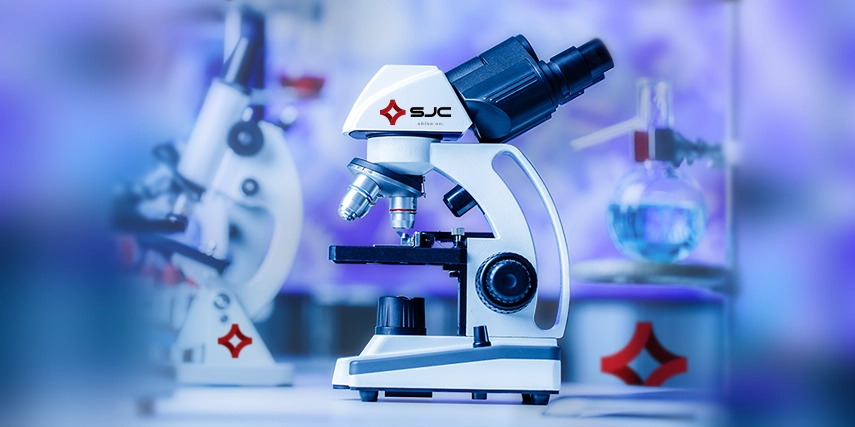 SJC Microscope in a darkened room with lab equipment surrounding it.