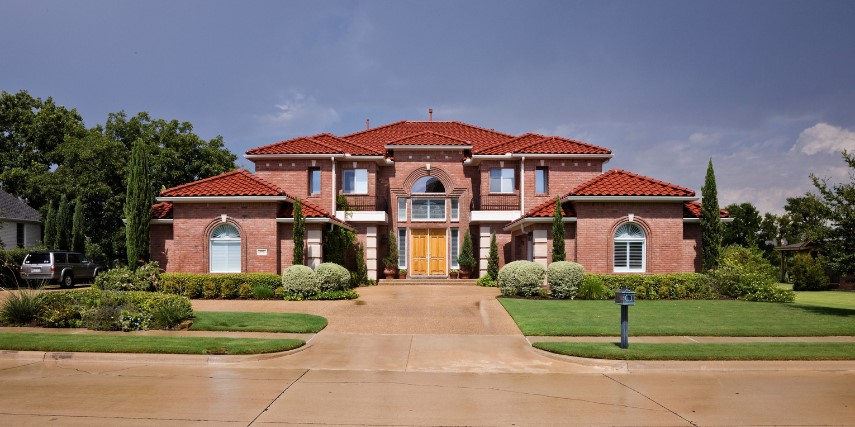 Street view of a large home with immaculate walls, roof and windows.