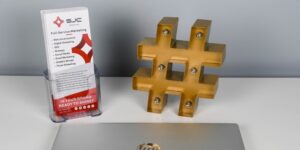 The edge of a laptop is visible by a display of brochures and a lighted hashtag sign.