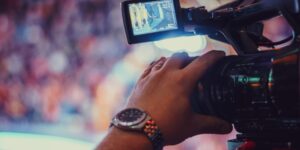 Close-up of a hand guiding a video camera at an event.