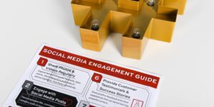 A gold, lighted hashtag is placed on a desk near a "social media engagement guide."