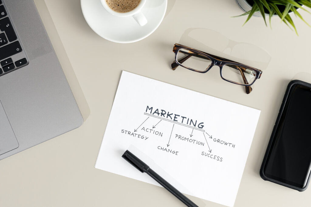 The word strategy written on a piece of paper with various marketing activity words written under it.