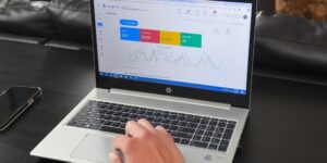 A laptop shows a Google Ads dashboard with various metrics.