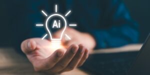 An open hand with a lighted lightbulb graphic floating above the hand with "Ai" inside the bulb.