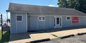 Exterior photo of Kingdom Cardz, a one-story building with a sidewalk in front.