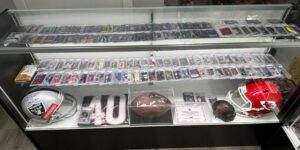 Close-up view of a display case at Kingdom Cardz, showing baseball cards and other memorabilia.