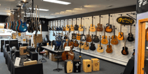 Rows of electric and acoustic guitars line the walls at Lanham Music, while box drums and equipment line the floor.