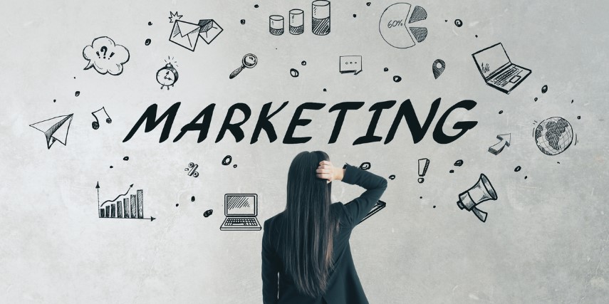 Back view of a woman looking at a wall full of marketing icons, scratching her head in confusion.