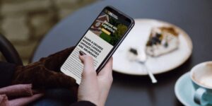 Closeup of a hand holding a phone where the person is reading content on a website.