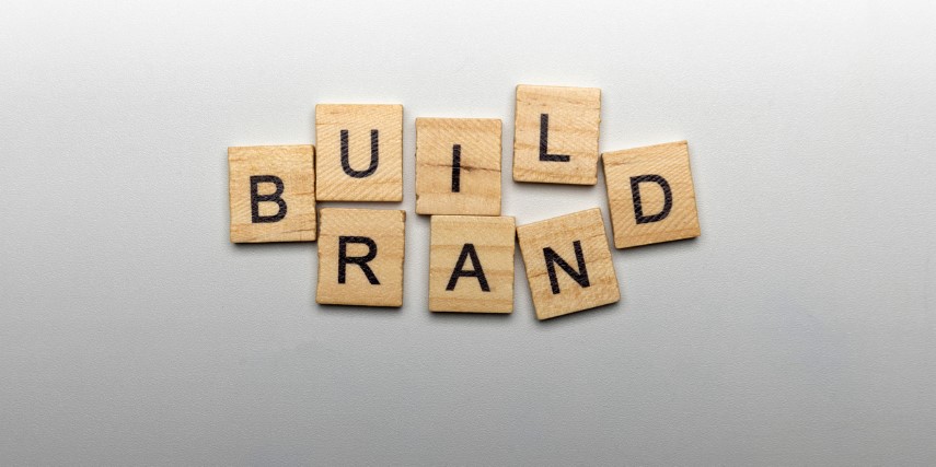 Scrabble-style tiles spell out "Build Brand" with the "B" and the "D" shared by both words.