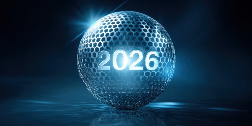 A large reflective silver ball has "2026" on it and it is lighted and has lights shining on it.