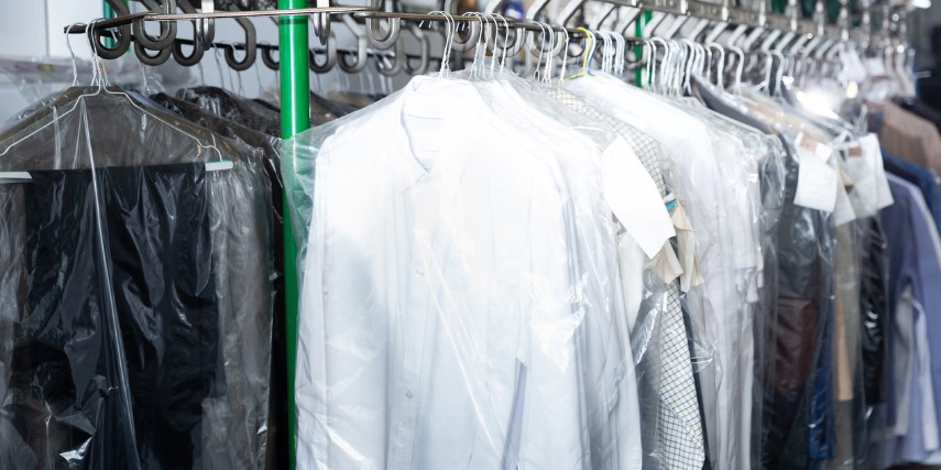 A rack of dry-cleaned garments hung on a dry-cleaning rack.