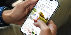 Close-up of a smartphone with a social media business profile on the screen.