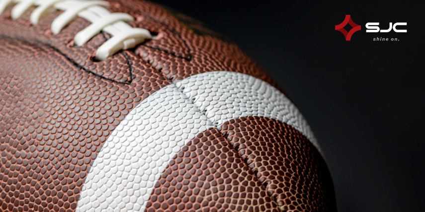 Close-up of a football with the SJC logo in the top right corner of the image.