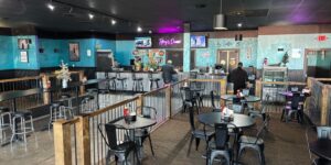 Inside view of a diner with blue walls and a smattering of tables across the room.