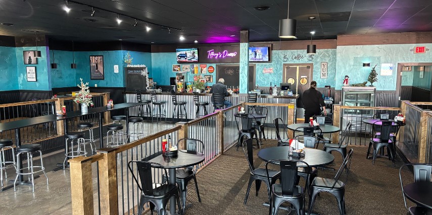 Inside view of a diner with blue walls and a smattering of tables across the room.
