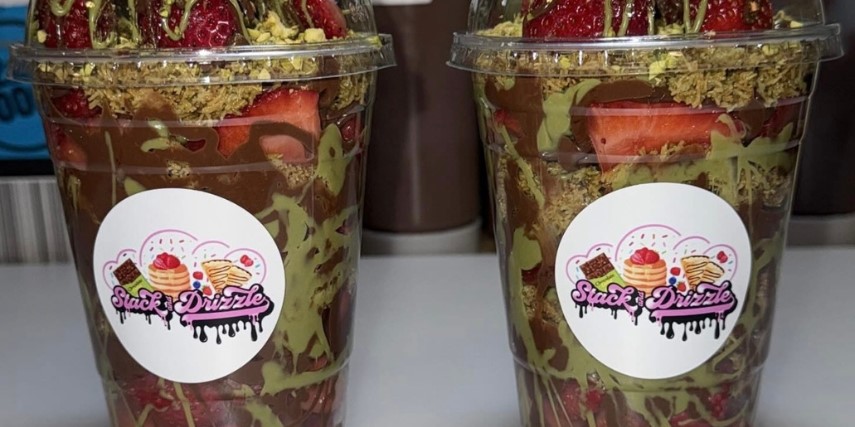 Two cups labeled with "Stack and Drizzle" and filled with strawberries and drizzled with Dubai chocolate flavors.