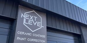 Exterior of Next Level Detailing, showing a painted exterior with a sign featuring the company's logo.