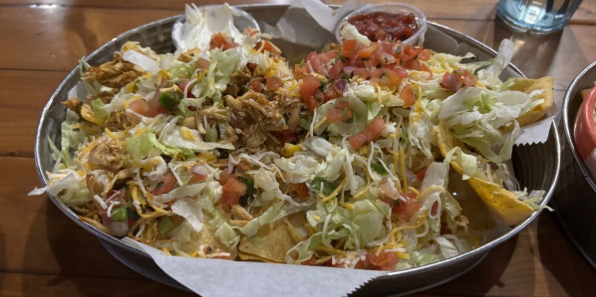 A basket of nachos topped with lettuce, tomatoes and all the fixings at Jake's Steakhouse and Sports Bar. 