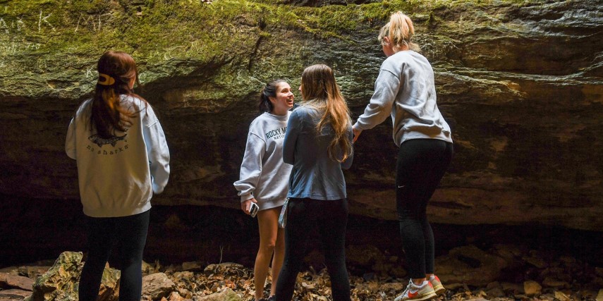 Four young women explore geologic formations in Rock Bridge Memorial State Park.