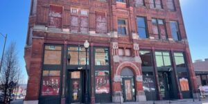 An older, large, multi-story brick building, viewed from the street.