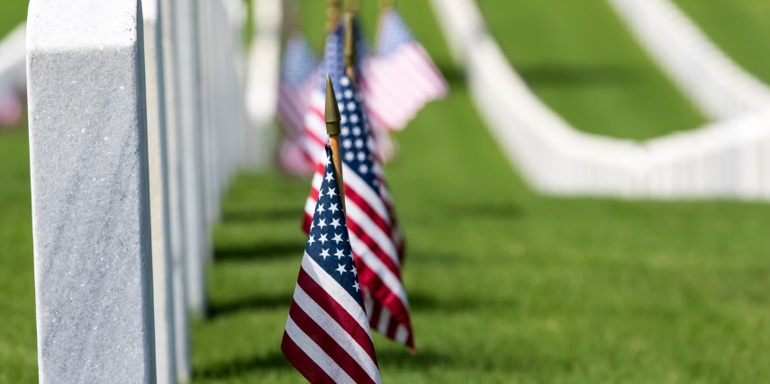 Image of a military cemetery, with a flag decorating each grave.