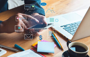 Laptop on desk with pens and notepads, surrounded by overlaying graphics related to omnichannel solutions