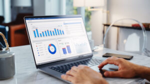 Close Up Of a Persons Hands Using Laptop Computer, Doing Data Analysis with Charts and Graphs. Young Man is Working from Modern Home, Using Touch Pad