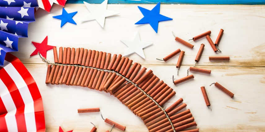 A string of firecrackers surrounded by American flag material and star confetti.