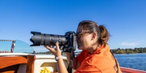 Side view of a photographer taking a picture from a boat.