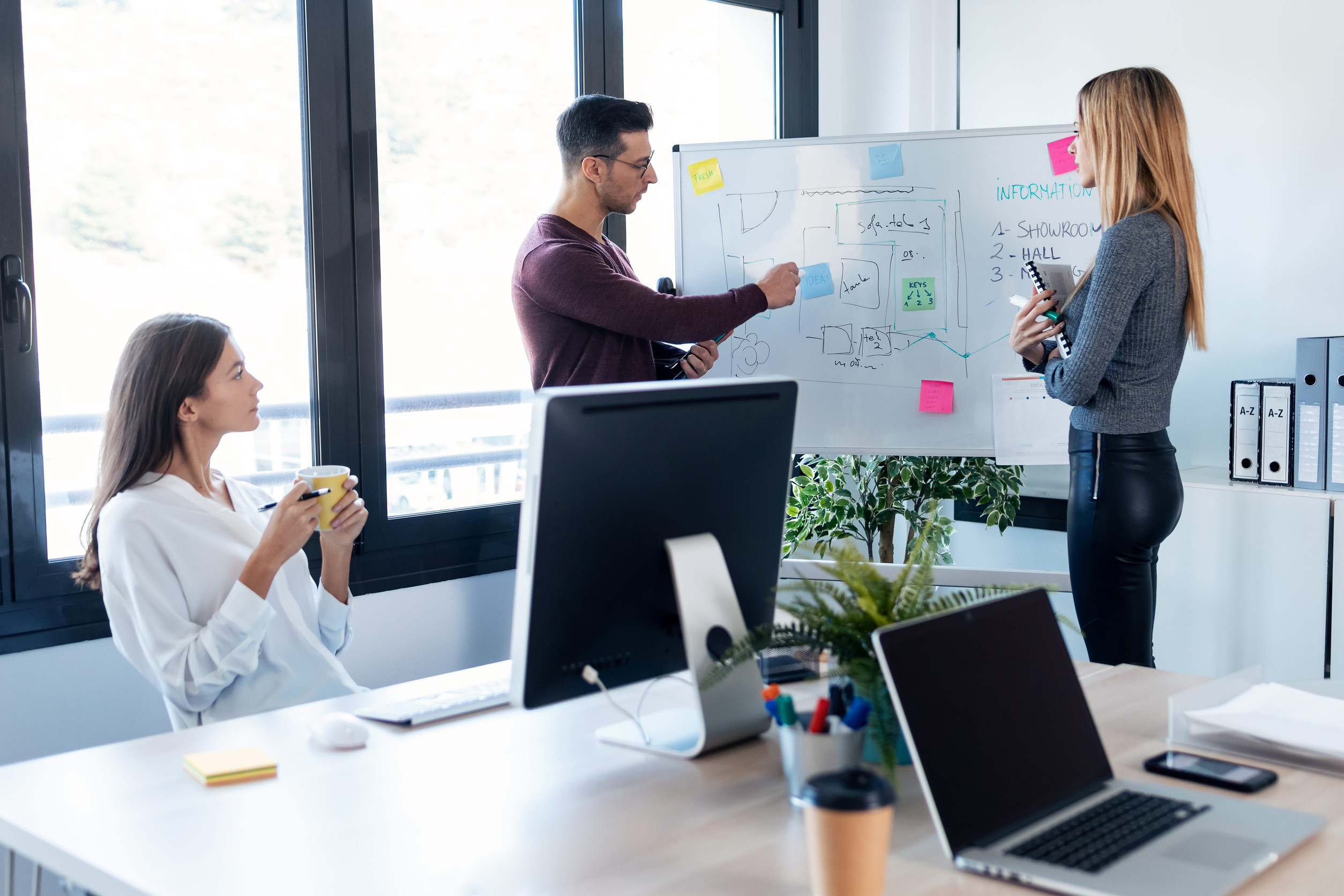 business team talking to their colleagues in white blackboard