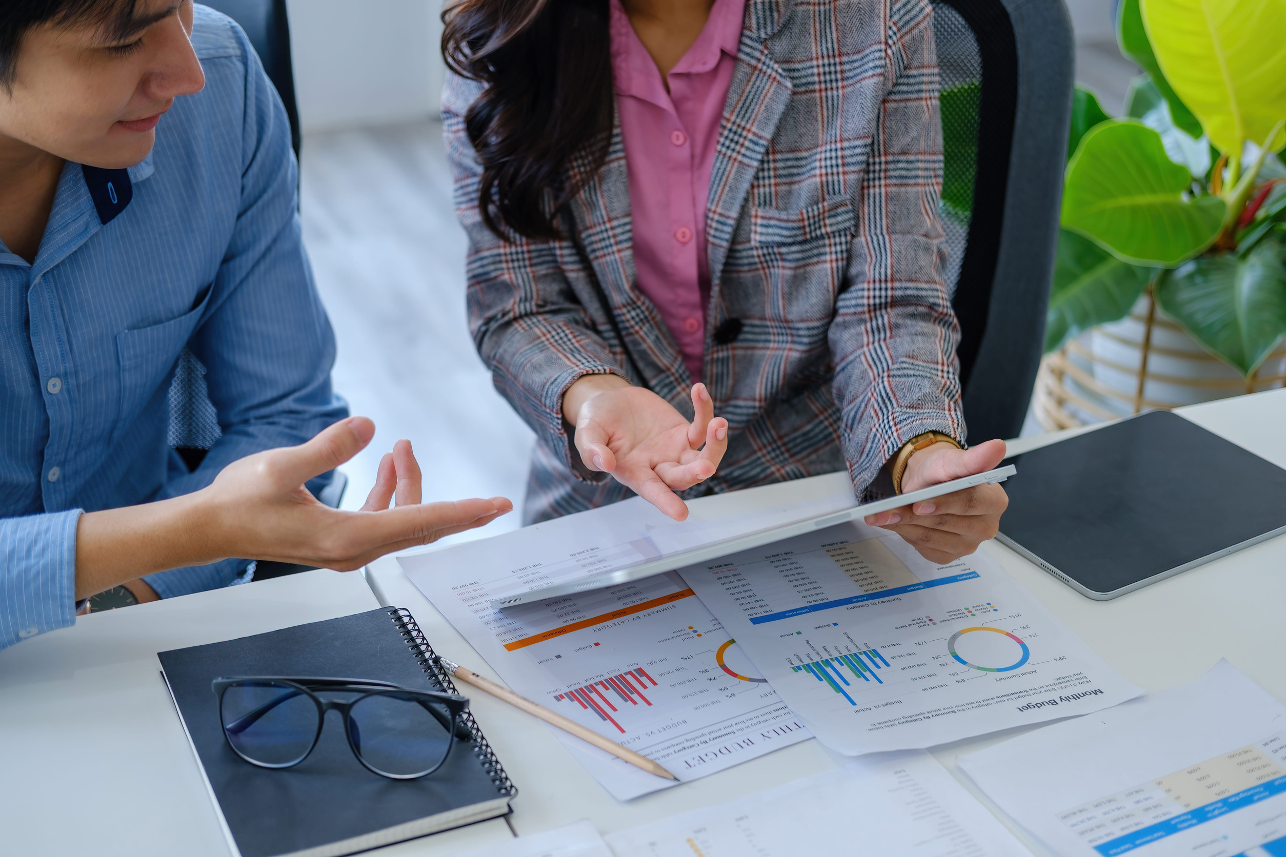 Marketing Consulting Two individuals sitting at a desk surrounded by paperwork and notes