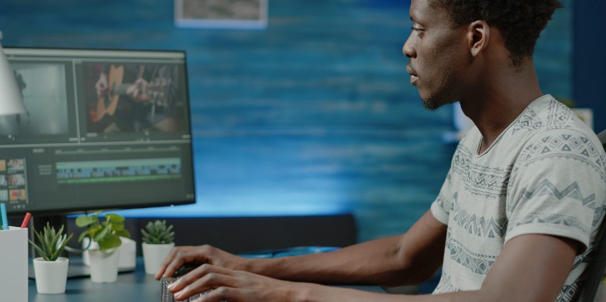 A videographer sits at a desk making edits to a production.