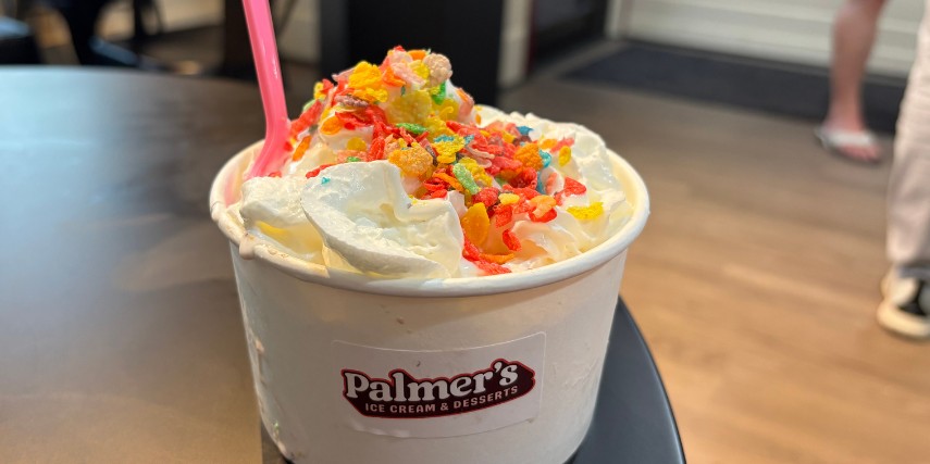 An ice cream treat with the Palmer's Ice Cream logo with a pink spoon, ready to enjoy.