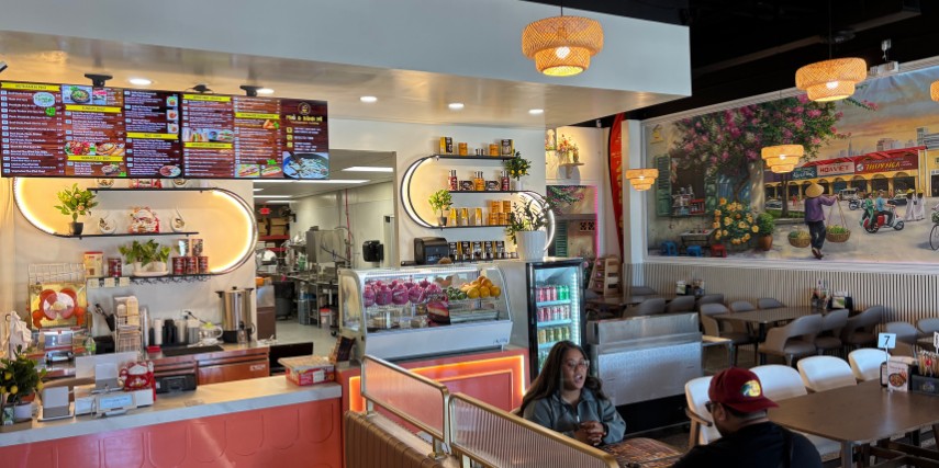 Interior image of Vietnamese restaurant shows the counter and a booth with customers enjoying food.