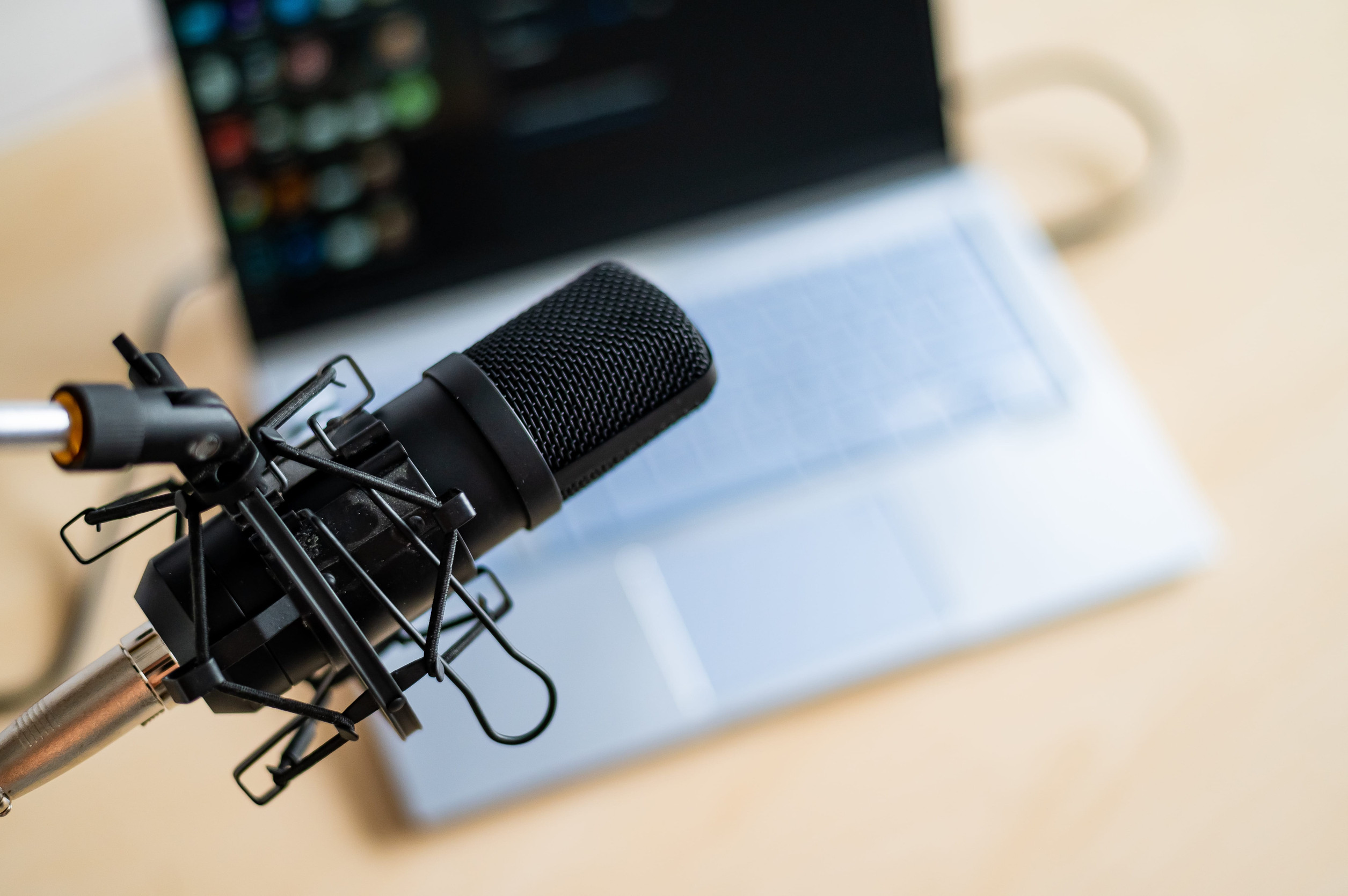 Audio Close-up of a professional microphone on the background of a laptop. Radio broadcasters desktop
