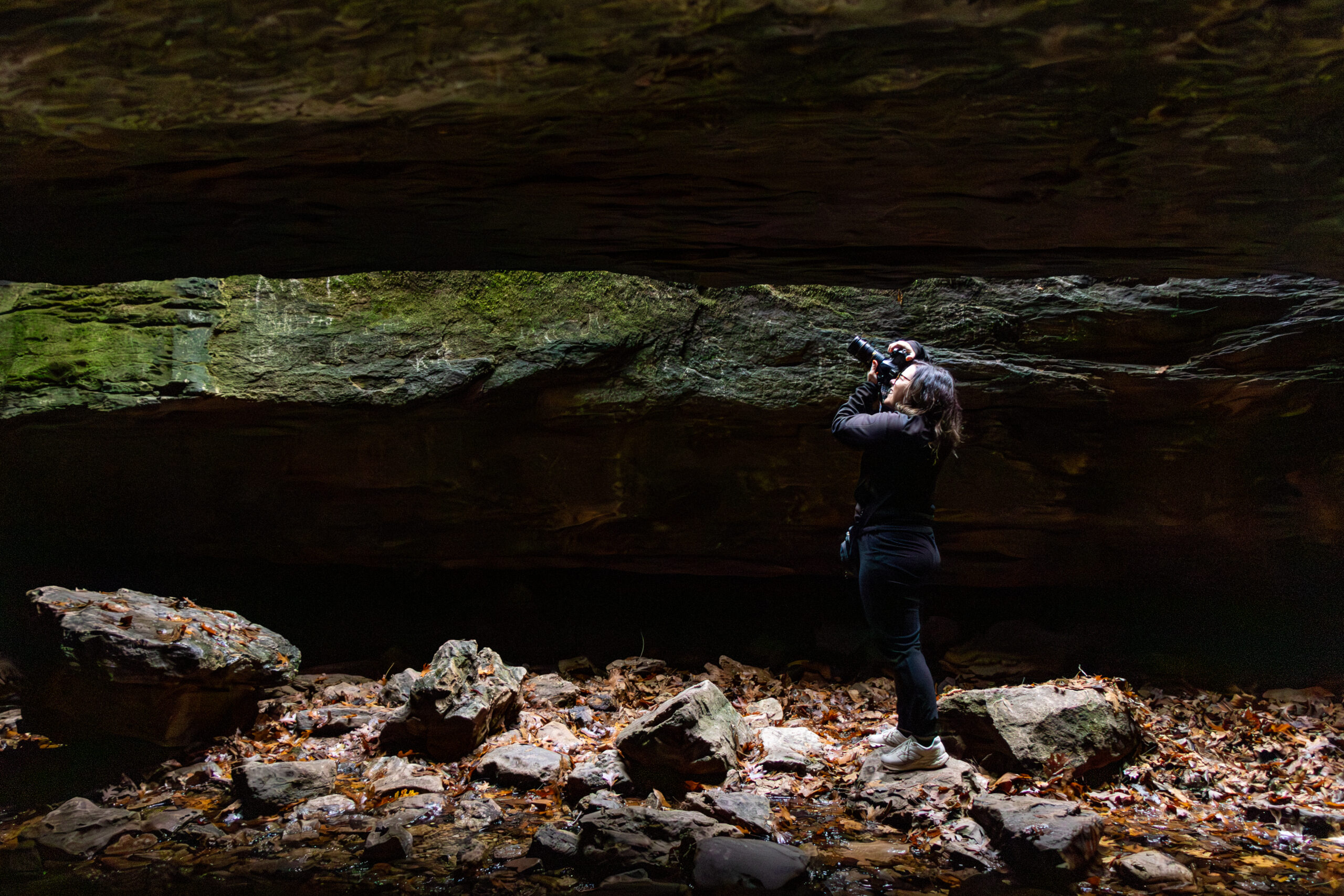 Photography Photographer standing on rocky ground taking a professional photo
