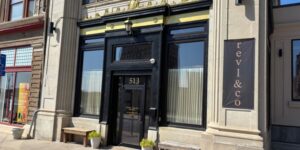 Exterior view of Revl & Co., with a bold black door and gold accents.