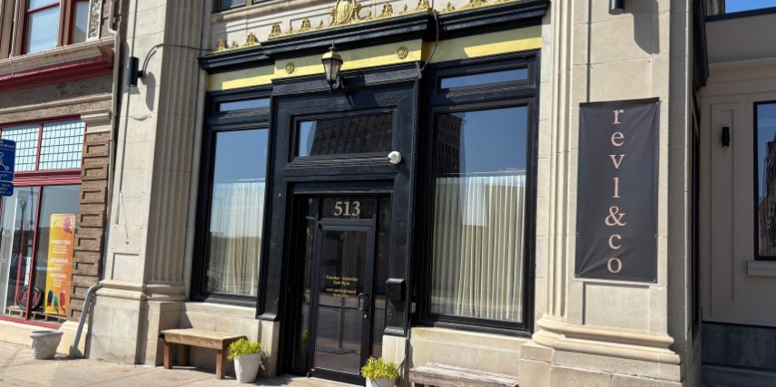 Exterior view of Revl & Co., with a bold black door and gold accents.