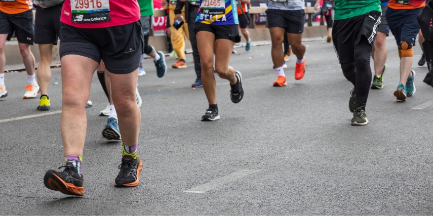 View of runners from the waist down as they compete in a road race.