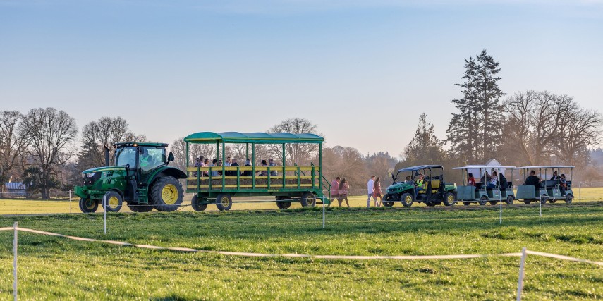 A tractor pulls a large wagon for a hayride with another tractor following it.